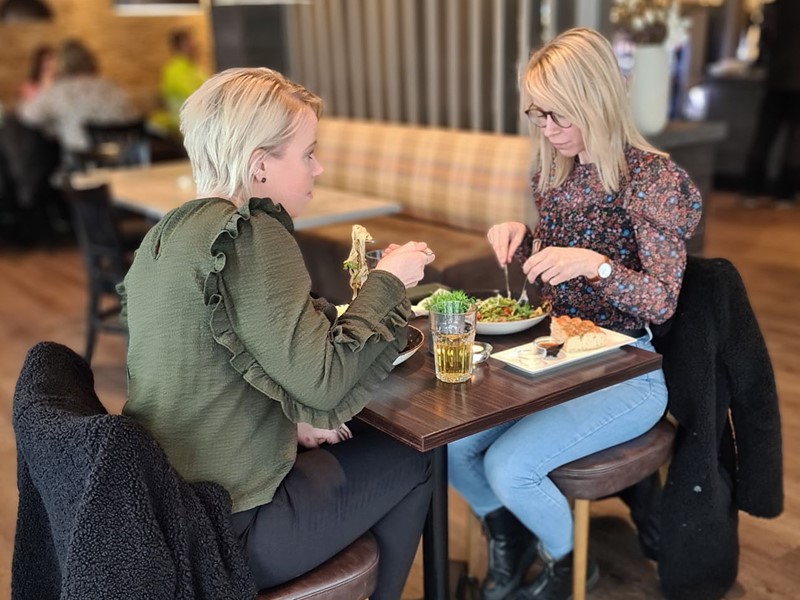 To unge damer spise lunsj i kaféen på Lampeland Hotell