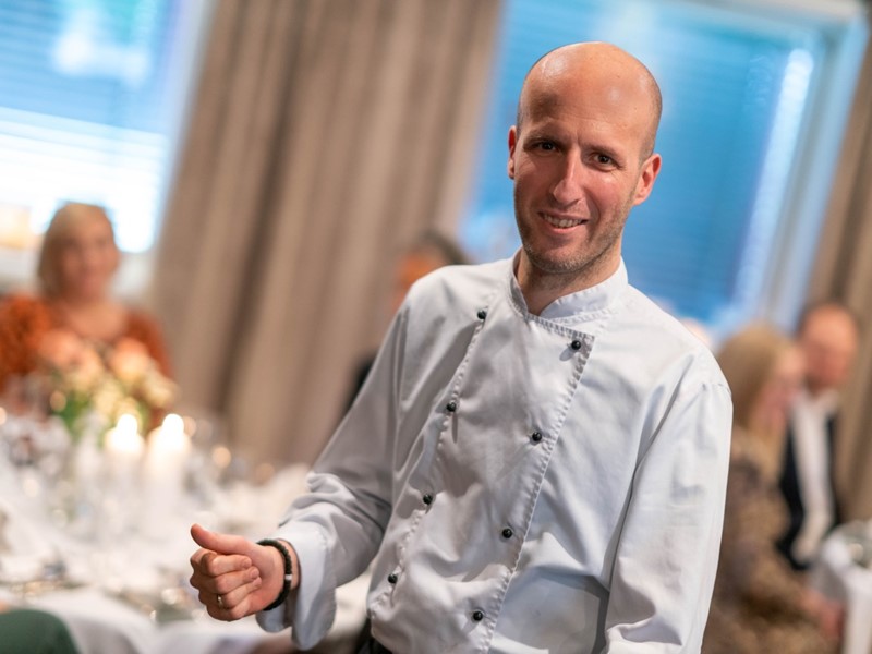 Mannlig kokk presenterer meny på Lampeland Hotell