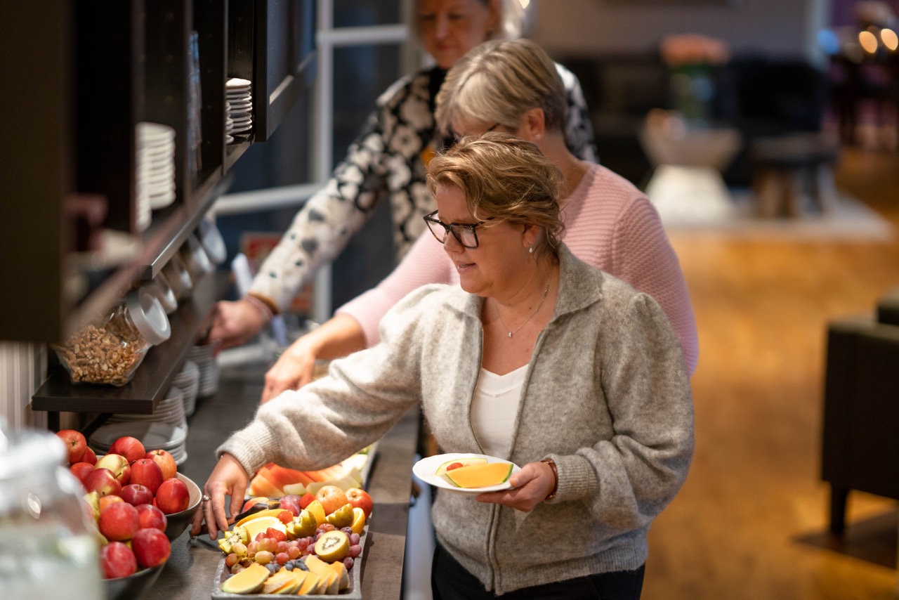 Smilende dame går inn i spisesa